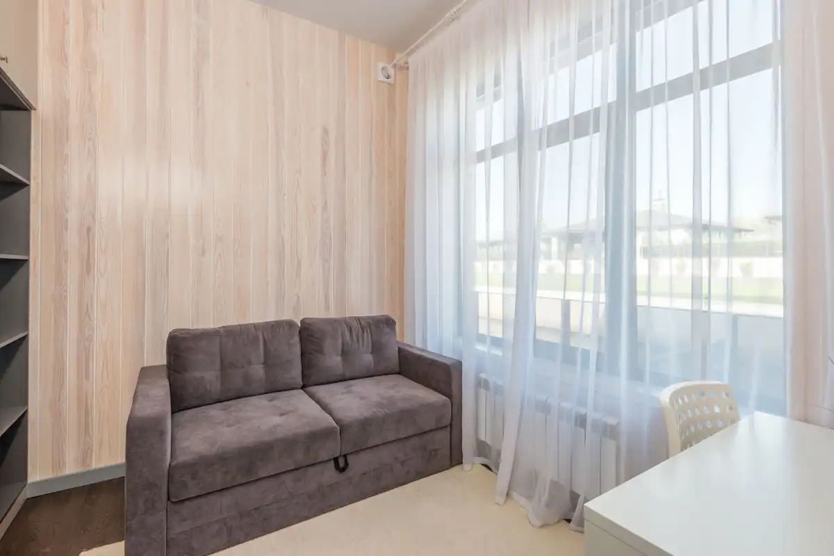 Apartament luminos cu canapea modernă și fereastră mare