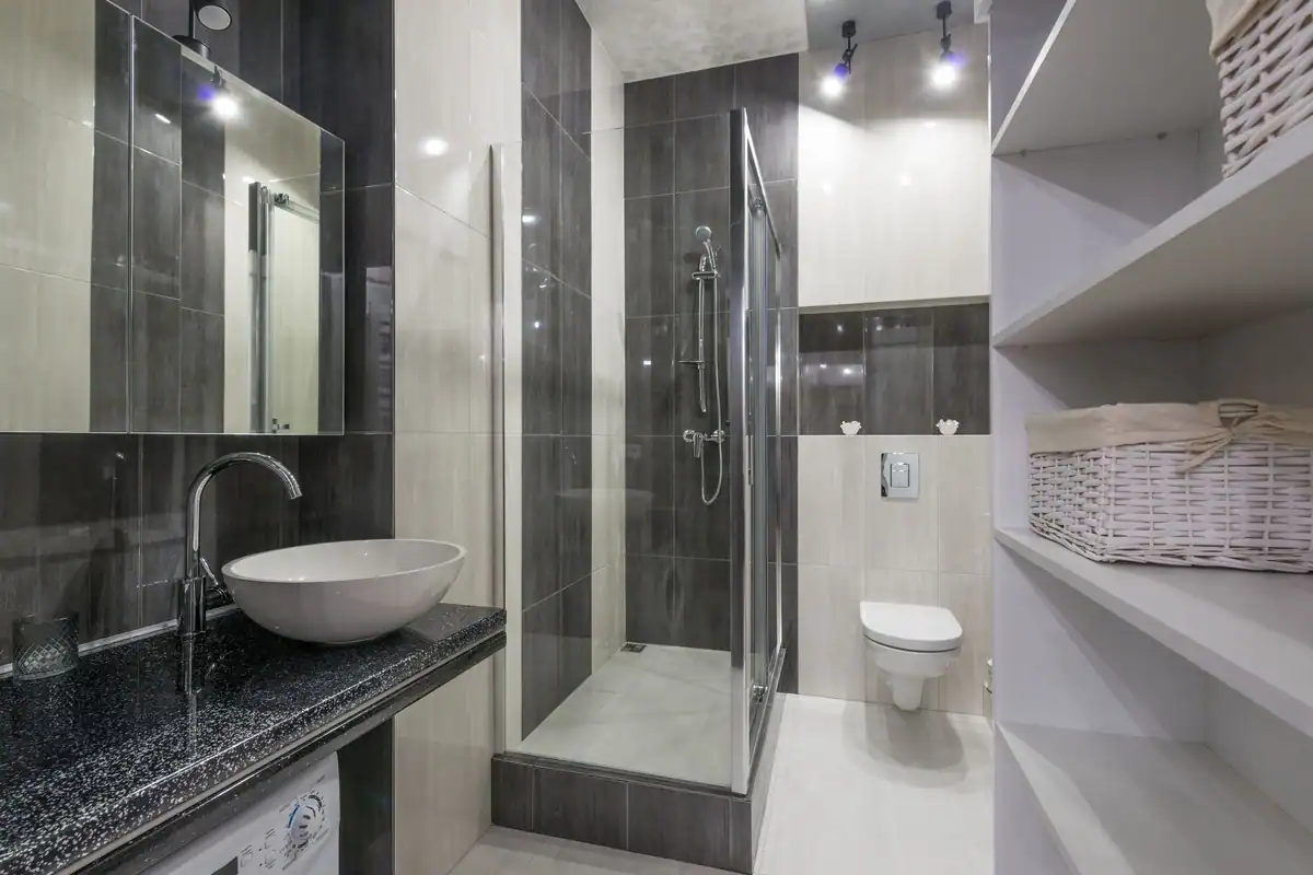 Baie contemporană cu duș din sticlă, lavoar și rafturi de depozitare