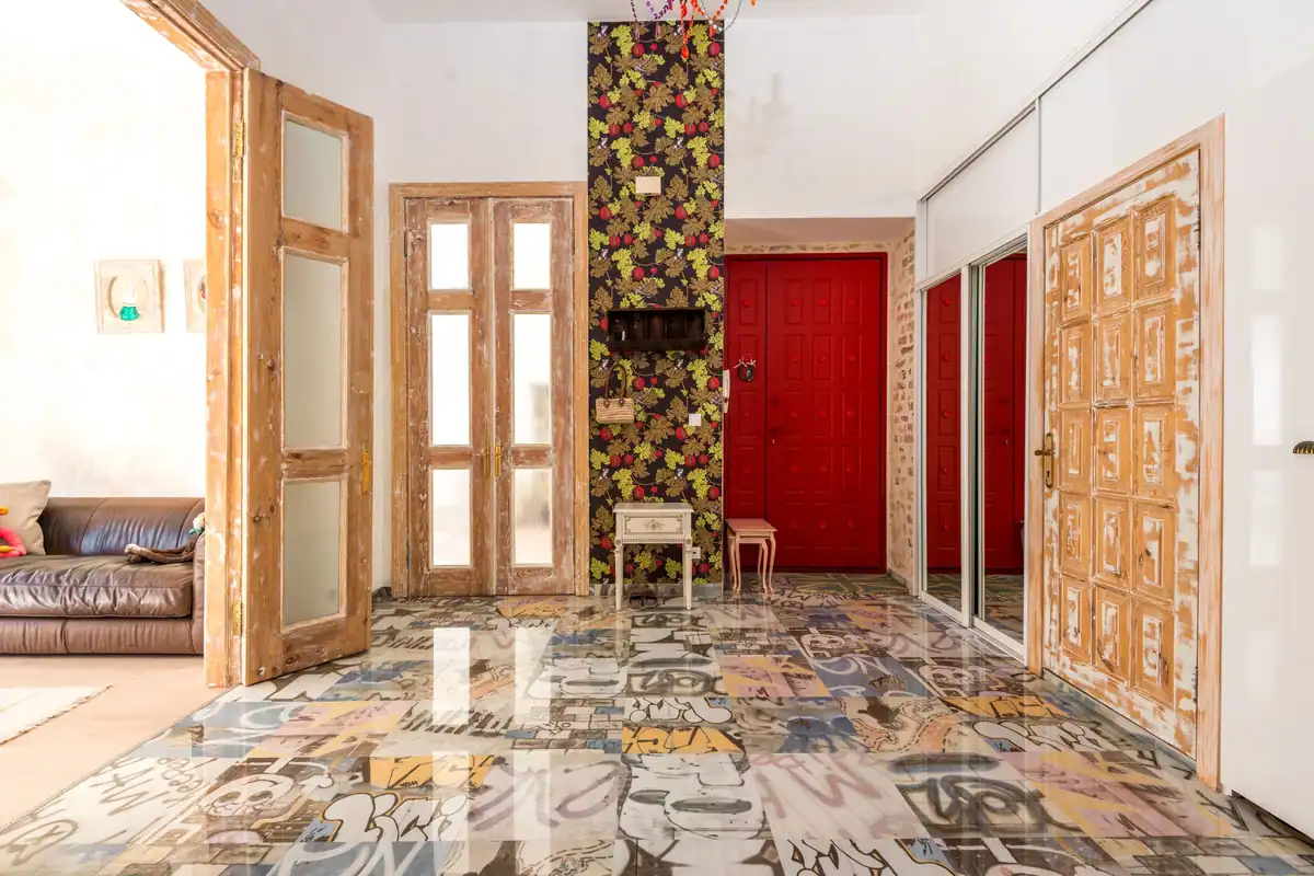 Interior eclectic plin de culoare, cu perete floral și uși rustice din lemn
