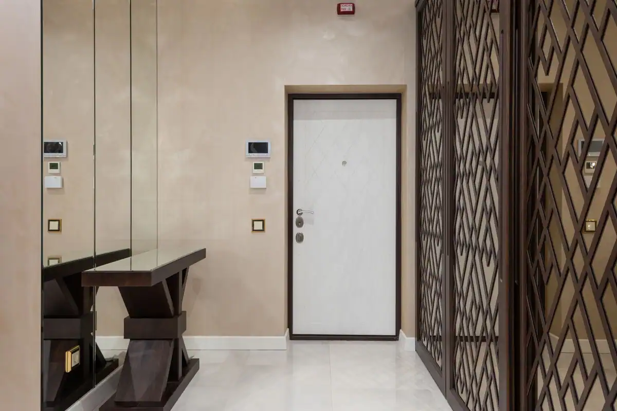 Hol de intrare elegant cu oglinzi, ușă modernă și mobilier în tonuri neutre