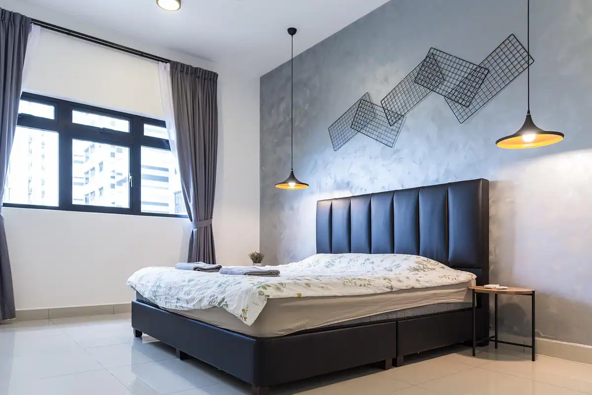 Dormitor cu perete de accent verde închis în spatele tăbliei patului, cu mobilier deschis la culoare