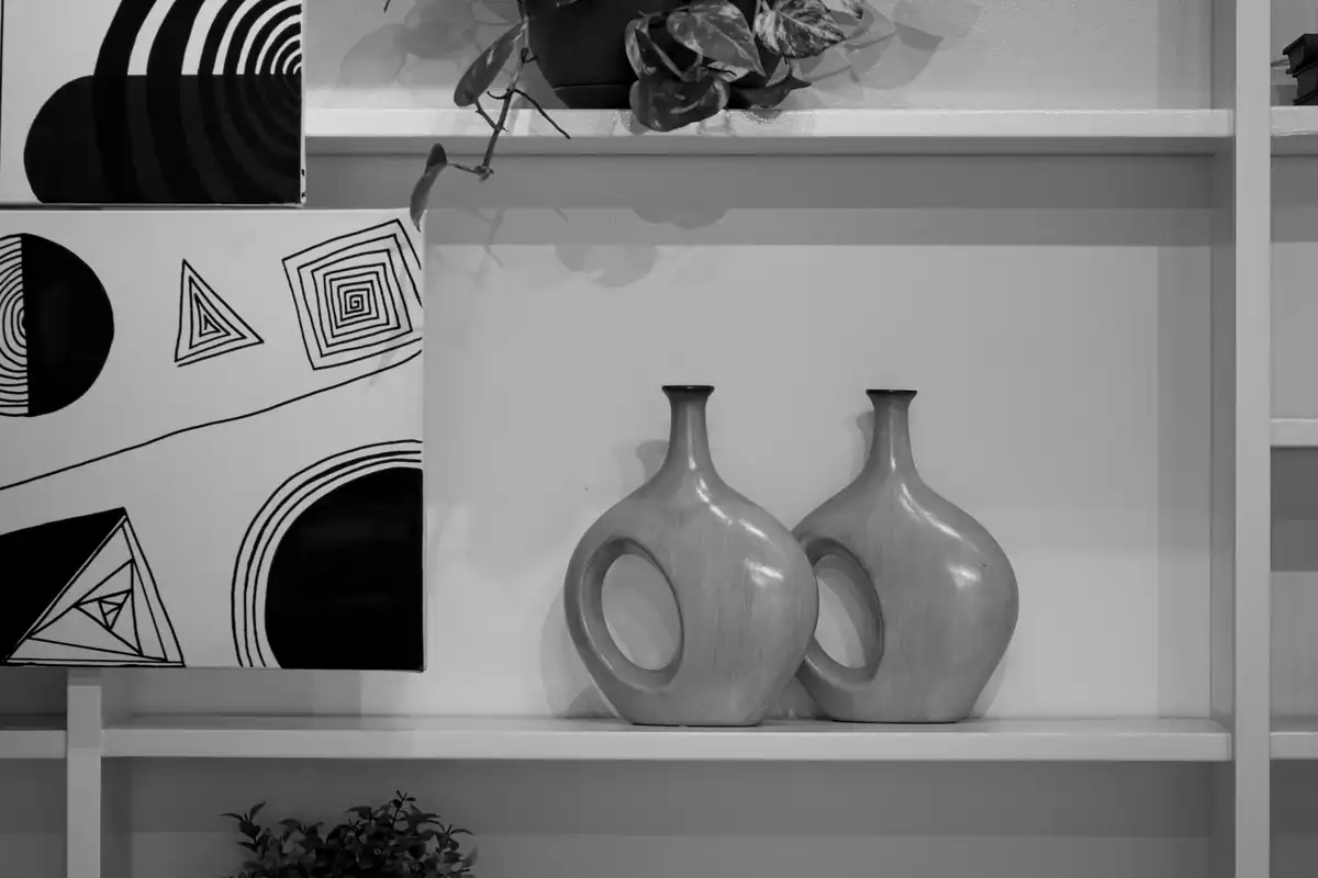 Raft cu decor alb-negru: tablou abstract și vaze elegante