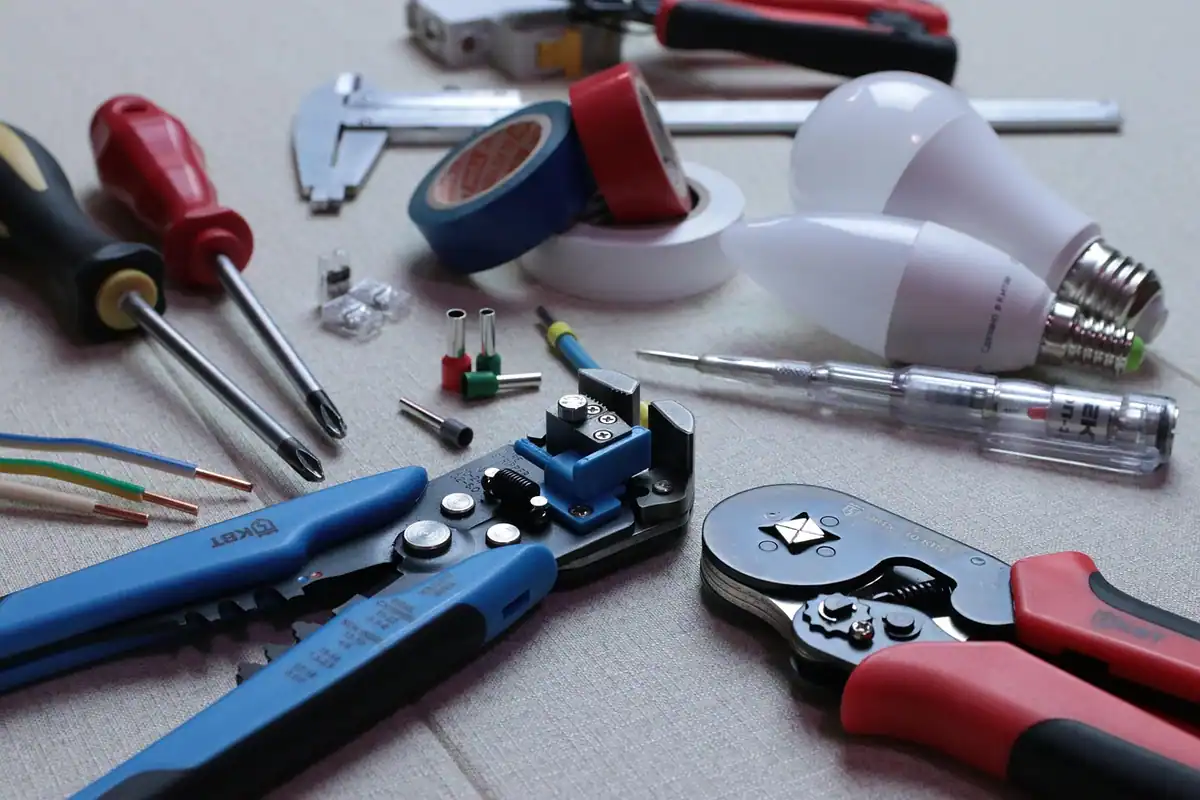 Electrician care trasează cablurile pentru prize lângă corpurile unei bucătării