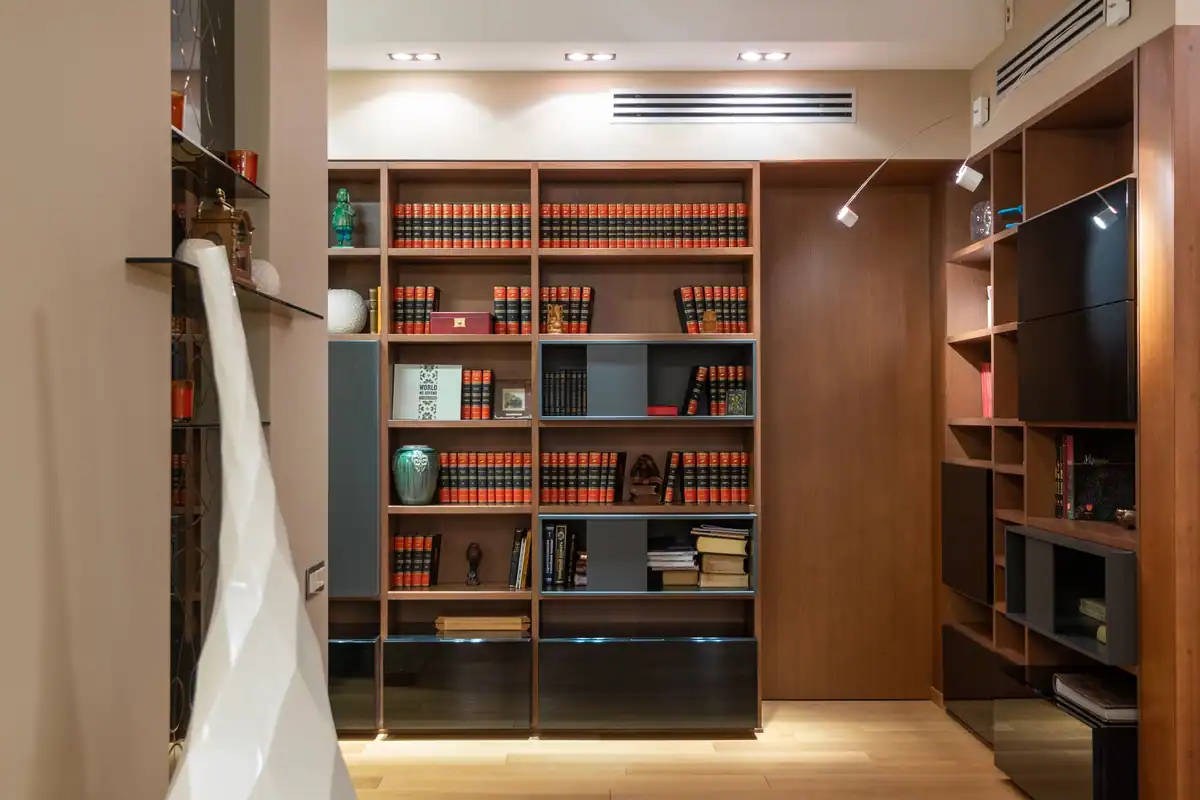 Bibliotecă din lemn plină cu cărți într-un apartament spațios