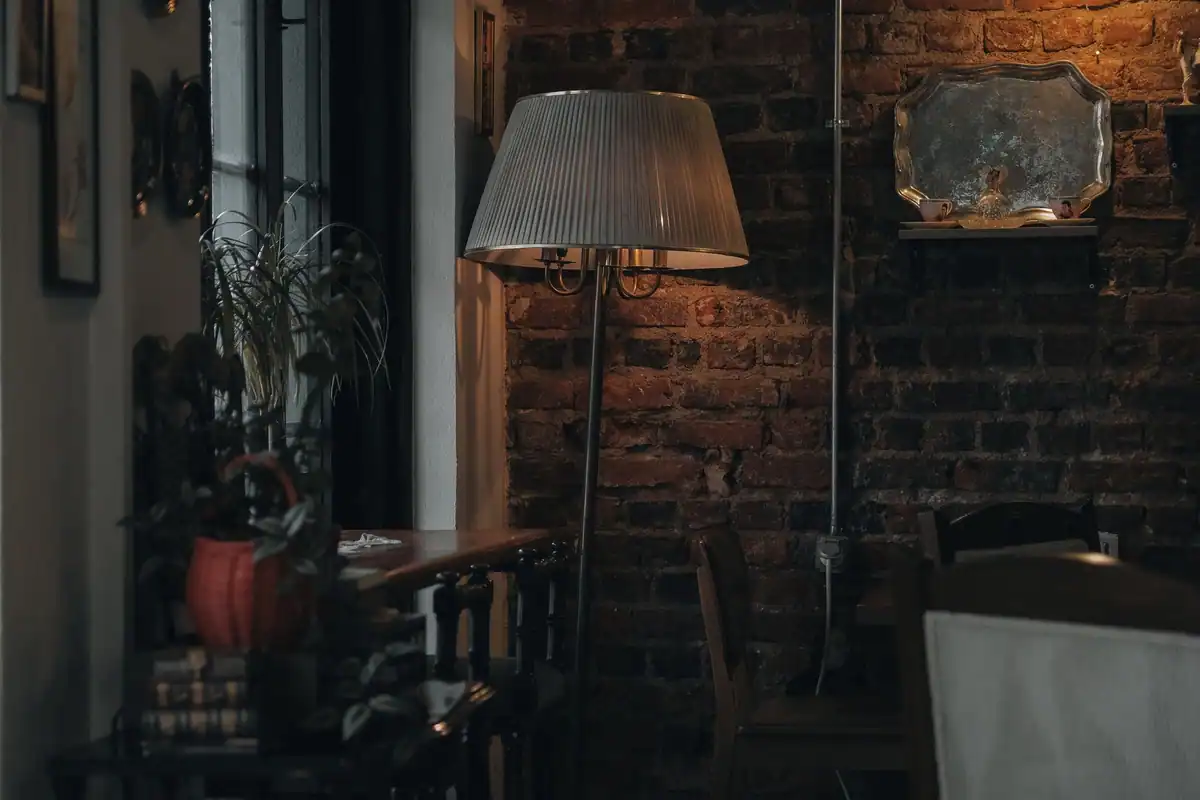 Living cald cu decor vintage, luminat de o lampă cu lumină blândă